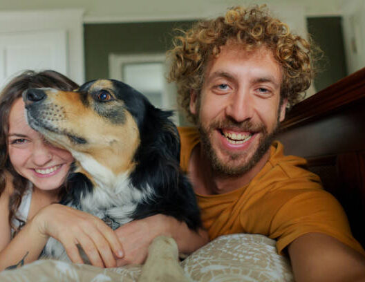 Portrait of cheerful smiling  woman with Australian Shepherd at home shot on camera film